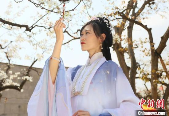 圖為蘭州青年身穿漢服在百年梨園賞景?！「哒?攝