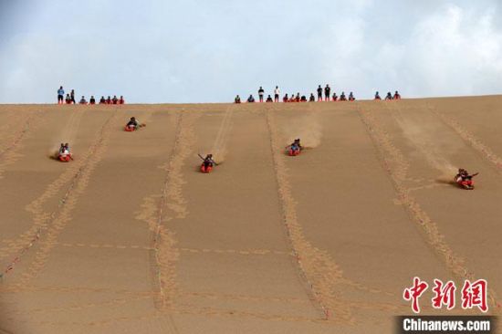 6月13日，敦煌鳴沙山月牙泉景區(qū)舉辦滑沙比賽。　張曉亮 攝