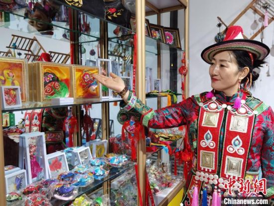 圖為身著民族服飾的隴原巧手展示手工藝品。(資料圖) 徐雪 攝