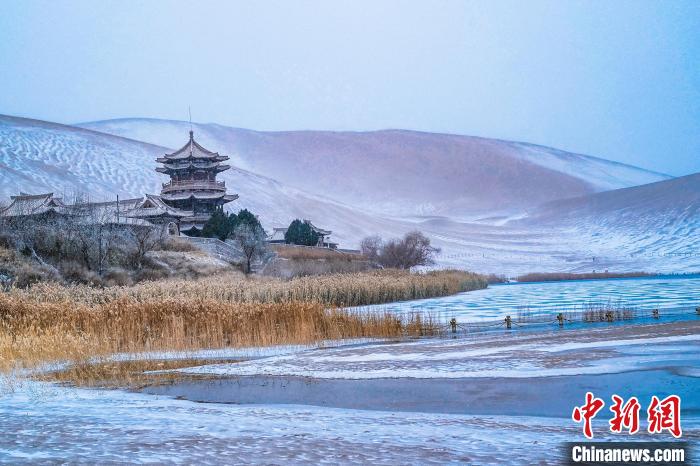 2021年11月28日，雪落鳴沙山月牙泉景區(qū)?！⊥醣筱y 攝
