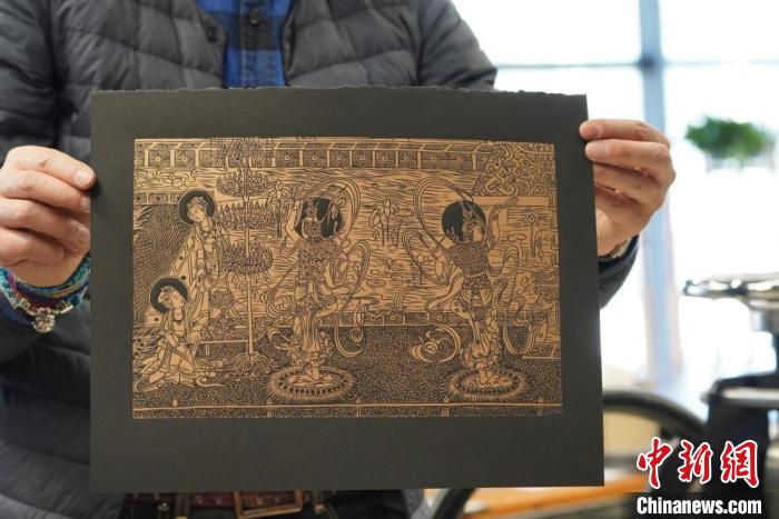 圖為手工書藝人展示敦煌雕版壁畫印刷品?！【琶赖┰?　攝