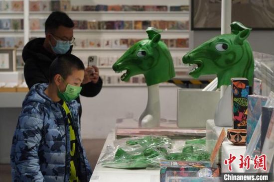 圖為“神馬來了”銅奔馬頭套吸引參觀者駐足?！【琶赖┰?攝