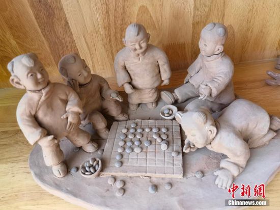 圖為泥塑作品展現(xiàn)下棋場(chǎng)景。 劉玉桃 攝