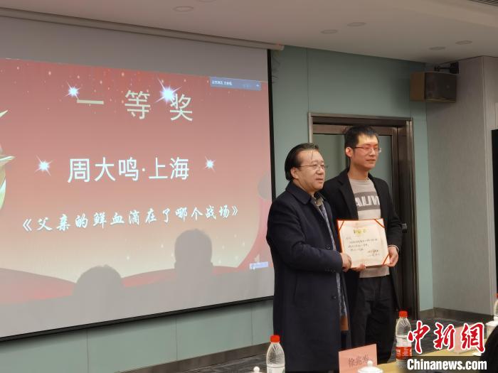 圖為作家、西北師范大學(xué)新聞與傳媒學(xué)院院長徐兆壽頒發(fā)一等獎證書，代領(lǐng)獎?wù)呱吓_領(lǐng)獎?！钅?攝