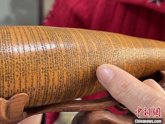 圖為長(zhǎng)約二十公分的長(zhǎng)條葫蘆雕刻佛教經(jīng)文作品?！堟?攝