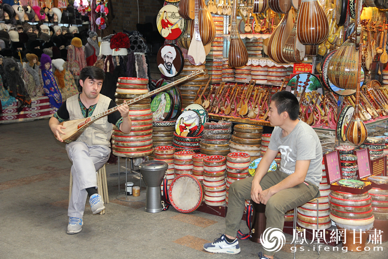 烏魯木齊二道橋巴扎內(nèi)，店主正在向客人展示樂器。楊文遠 攝