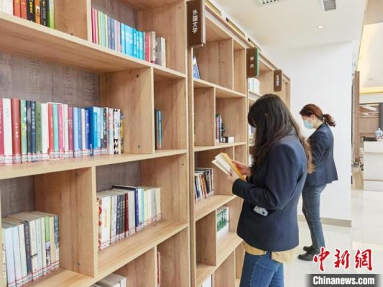 圖為在甘肅公航旅建設集團有限公司的職工書屋，職工挑選書籍?！⌒煅?攝