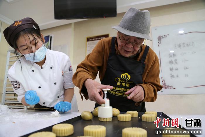 當(dāng)日，受邀參加活動的臺胞臺屬代表、兩岸婚姻及子女、在甘臺商代表等歡聚一堂。圖為77歲的在甘臺胞潘天鑒制作月餅。九美旦增 攝