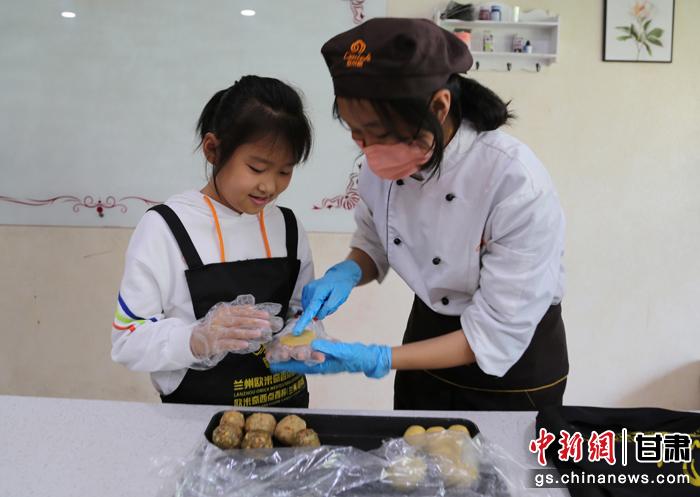 圖為在甘臺胞小朋友在工作人員指導(dǎo)下制作月餅。九美旦增 攝