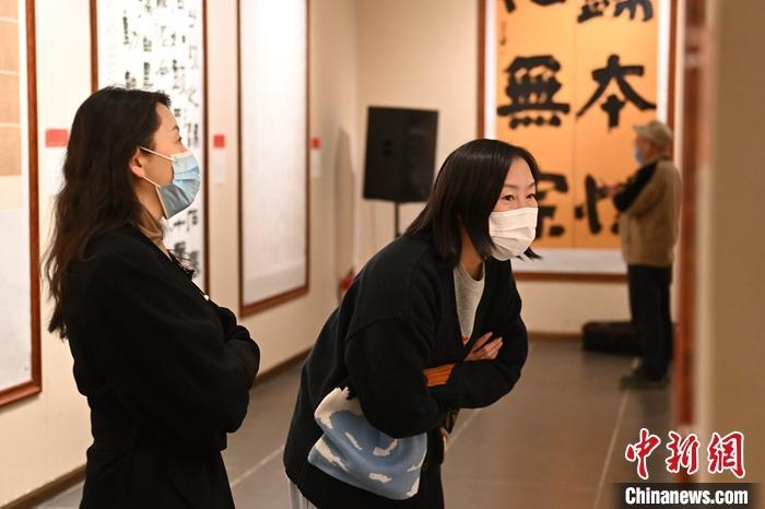 圖為甘肅蘭州，參展書(shū)法作品吸引參觀者。 中新社記者 李亞龍 攝