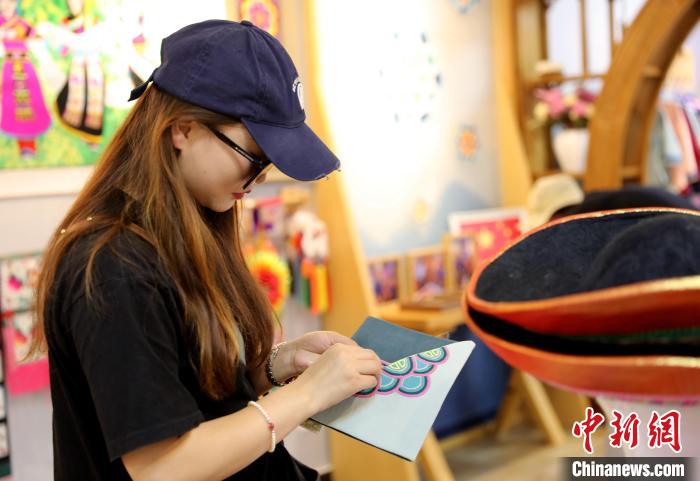 圖為民眾體驗(yàn)國家級非遺項目盤繡技藝?！⊙Φ?攝