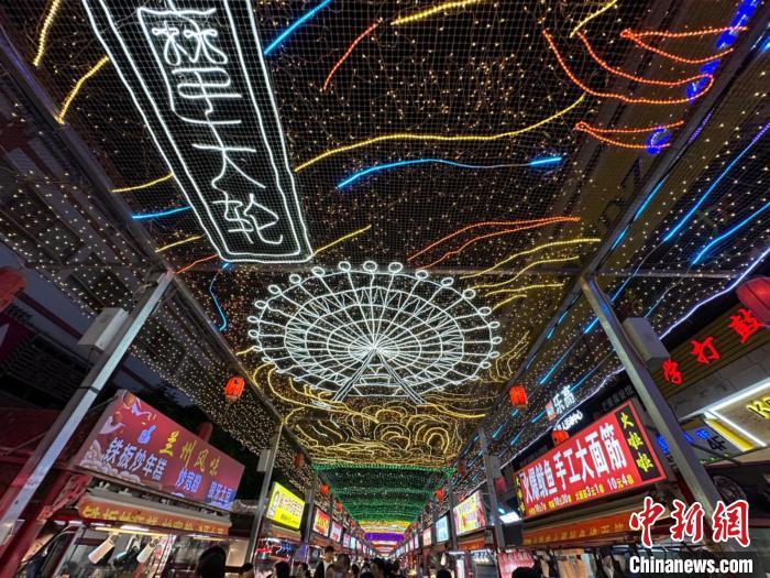 圖為明清街夜市燈光點(diǎn)亮具有武威文化元素的“摩天輪”彩燈。　戴文昌 攝</p><p>